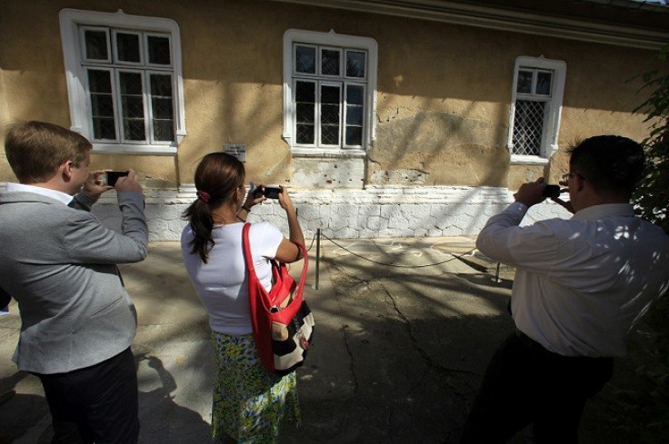 Visitors take pictures of the spot where Romania's late communist dictator Nicolae Ceausescu and his wife Elena were executed (Reuters)