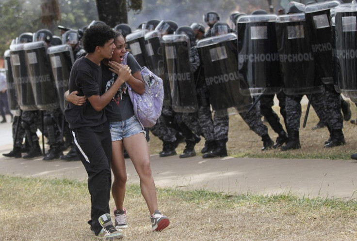 A couple attempt to flee unrest outside brasilia's mane garrincha stadium yesterday.