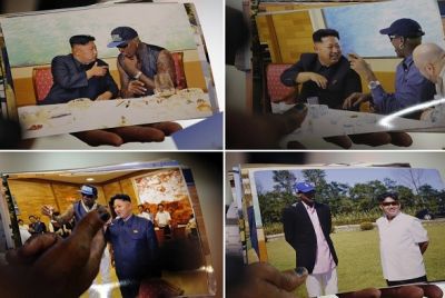 Dennis Rodman shows pictures he took with North Korean leader Kim Jong-un to the media (Reuters)