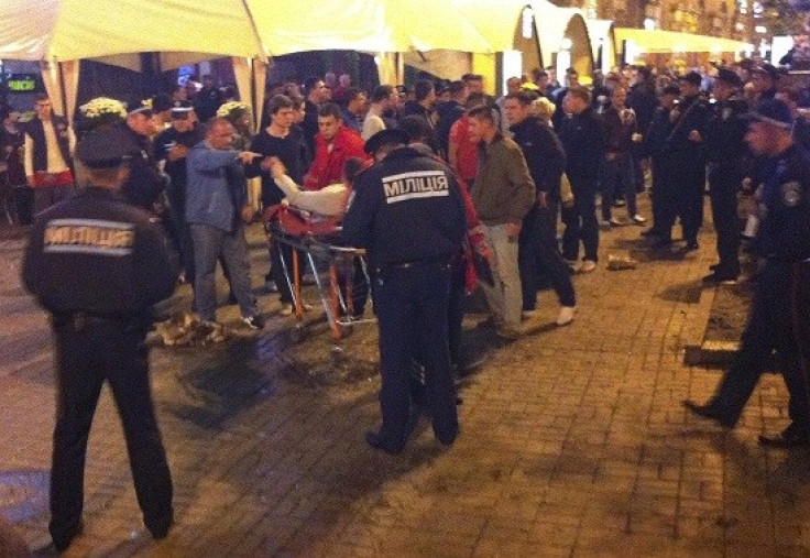 An injured English football fan lies on a stretcher and surrounded by medical personnel and police in central Kiev (Reuters)