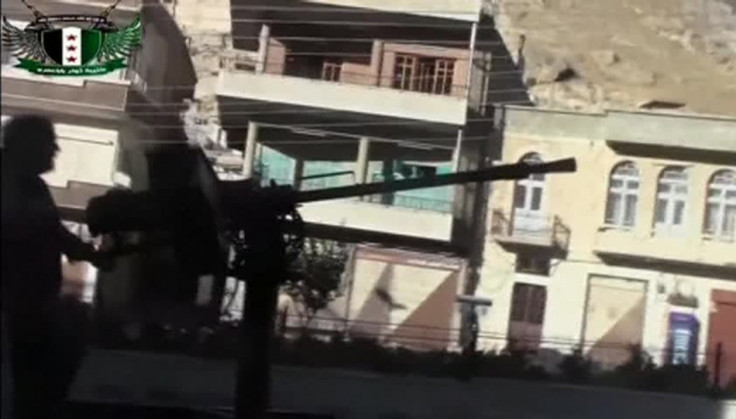 A Syrian rebel fires a heavy machine gun mounted on the back of a vehicle in Maaloula, a suburb of Damascus, in this image taken from a September 4, 2013 video footag