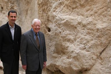 Syria's President Bashar al-Assad (L) walks with former U.S. president Jimmy Carter, at mountain pass of St. Taqla convent, during a visit to the historic city of Maaloula,