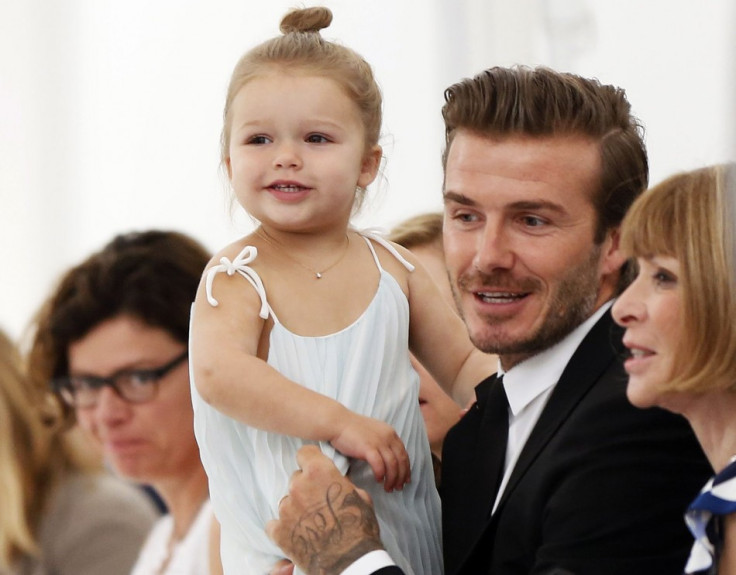 Former England soccer captain David Beckham holds his daughter Harper as he speaks to Vogue editor Anna Wintour while waiting for a presentation of the Victoria Beckham Spring/Summer 2014 collection during New York Fashion Week, September 8, 2013. (REUTER