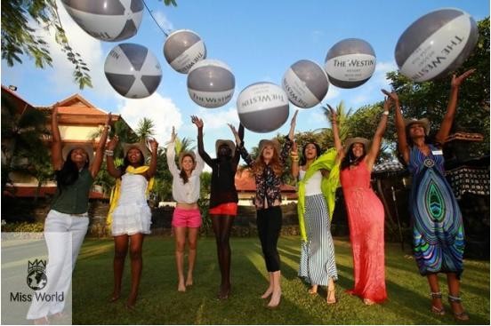 Miss World contestants throw balloons into the air before releasing baby turtles into the wild.