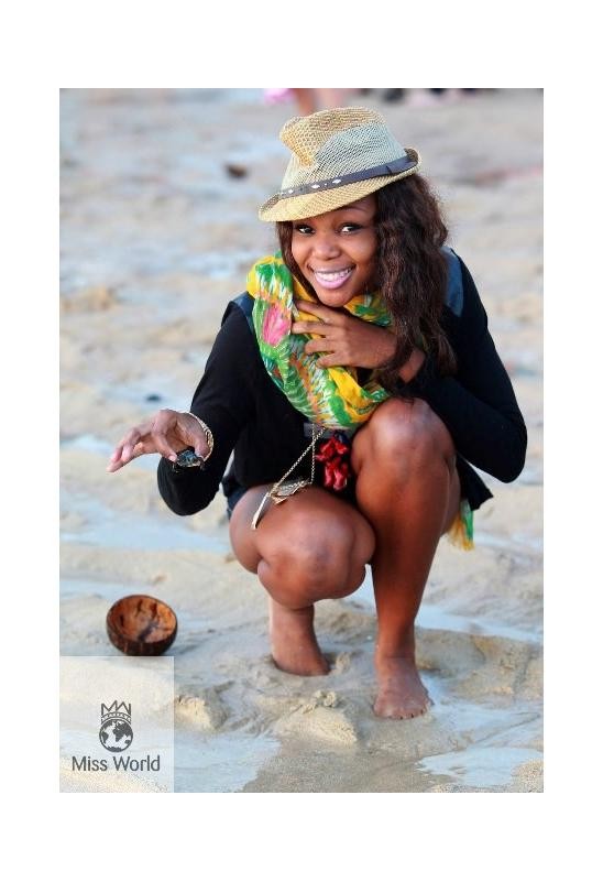 Miss World contestant smiles after baby turtles are released into the wild.