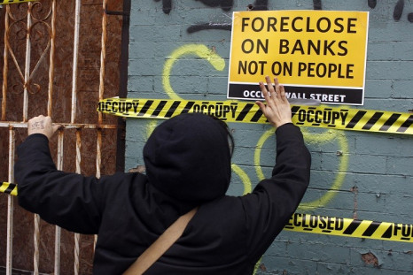 An Occupy Wall Street demonstrators pastes tape and signs to a foreclosed property in the East New York section of Brooklyn (Photo: Reuters)
