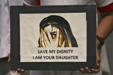 A schoolgirl holds a placard during a prayer meeting for a five-year-old rape victim in Jammu April 20, 2013. A five year-old girl was kept in captivity for 40 hours and allegedly raped and tortured in Delhi, police said, reviving memories of a brutal Dec