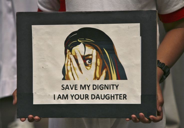 A schoolgirl holds a placard during a prayer meeting for a five-year-old rape victim in Jammu April 20, 2013. A five year-old girl was kept in captivity for 40 hours and allegedly raped and tortured in Delhi, police said, reviving memories of a brutal Dec
