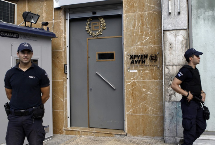 Police stand guard outside the Golden Dawn office in Athens.