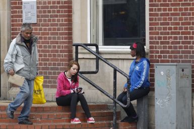 A young woman checks her smartphone outside a job centre in Leicester