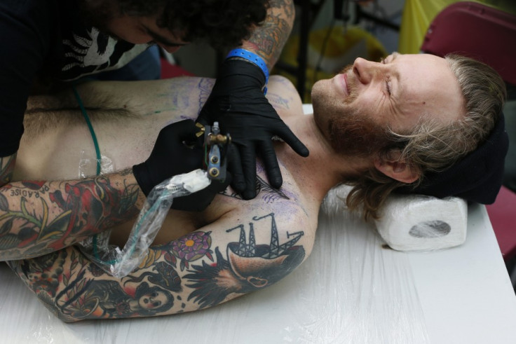 Emil Sarelind is tattooed by tattoo artists Deno (L).
