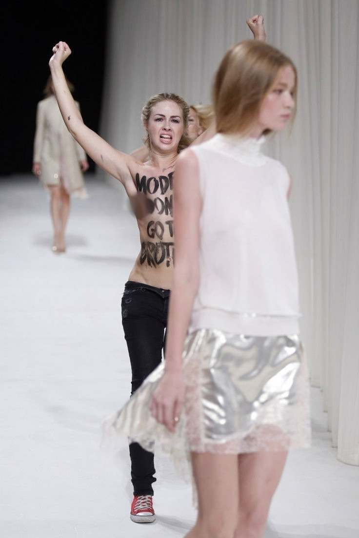 Paris Fashion Week model almost oblivious to topless Femen protest against fashion industry