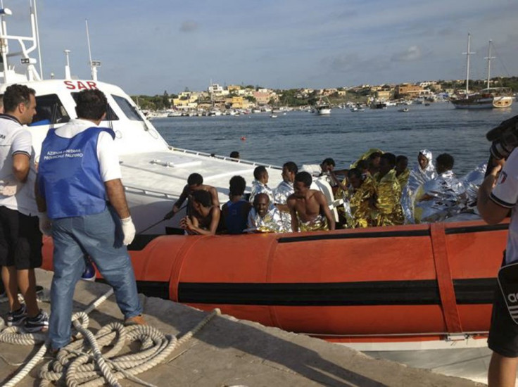 Rescued migrants arrive onboard a coastguard vessel at the harbour of Lampedusa