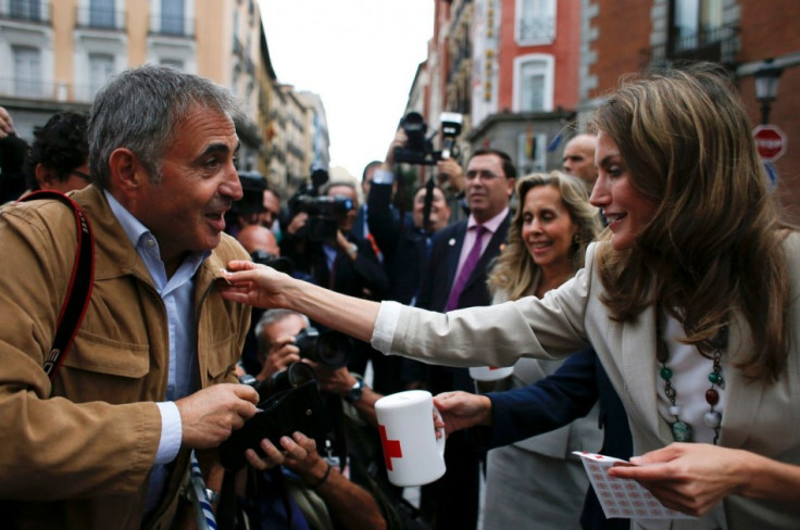 Princess Letizia puts a Red Cross sticker on the jacket of Spanish photographer Roberto Fernandeza during the event. (Photo: REUTERS/Susana Vera)