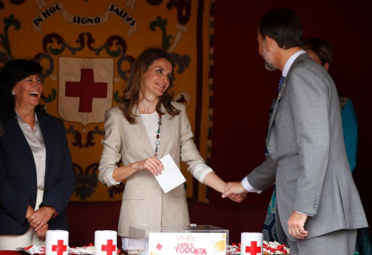 Princess Letizia holds the hand of her husband, Spain's Crown Prince Felipe, as she collects money donations. (Photo: REUTERS/Susana Vera)