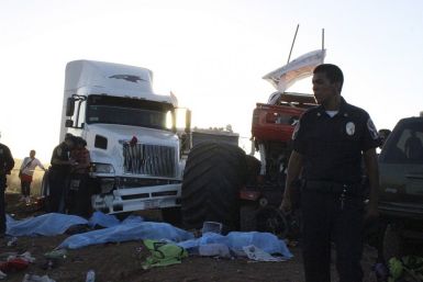 A police officer looks on as bodies lie covered withsheets after a monster truck ploughed into a crowd of spectators in Mexico.