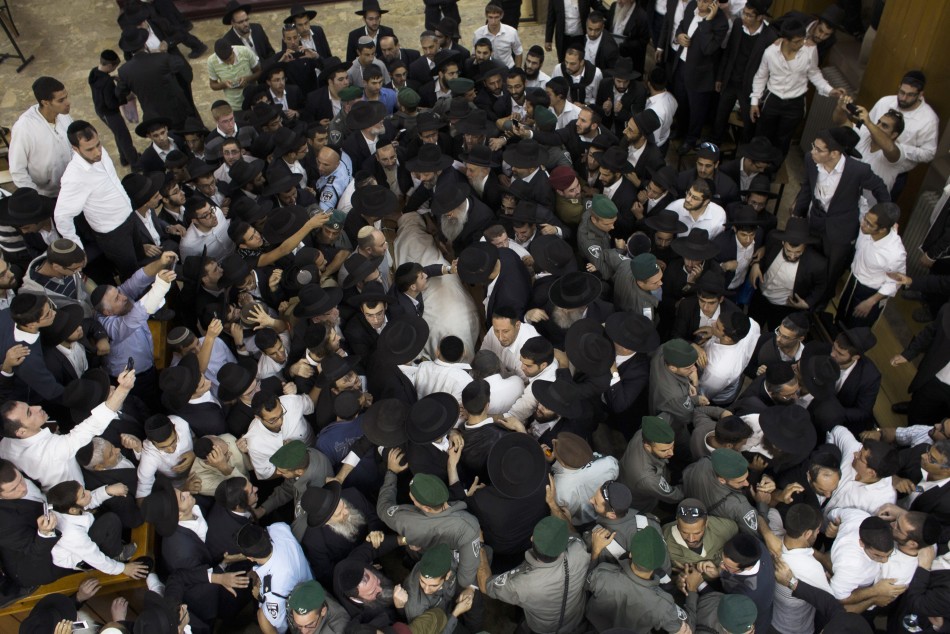 Ultra-Orthodox Jewish men gather near the body of Rabbi Ovadia Yosef