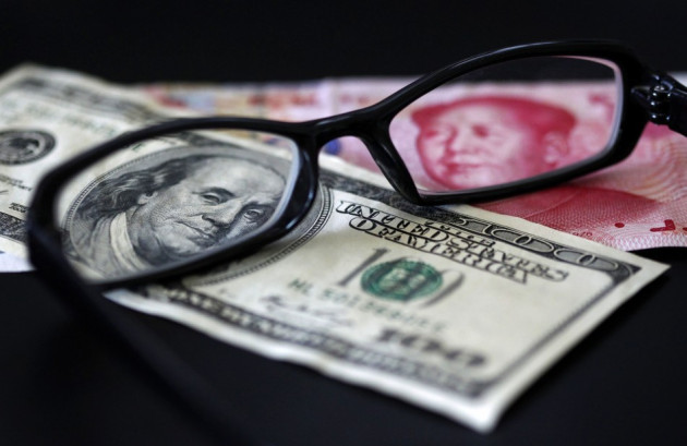 A U.S. dollar note and a Chinese yuan banknotes A U.S. dollar note and a Chinese yuan banknotes