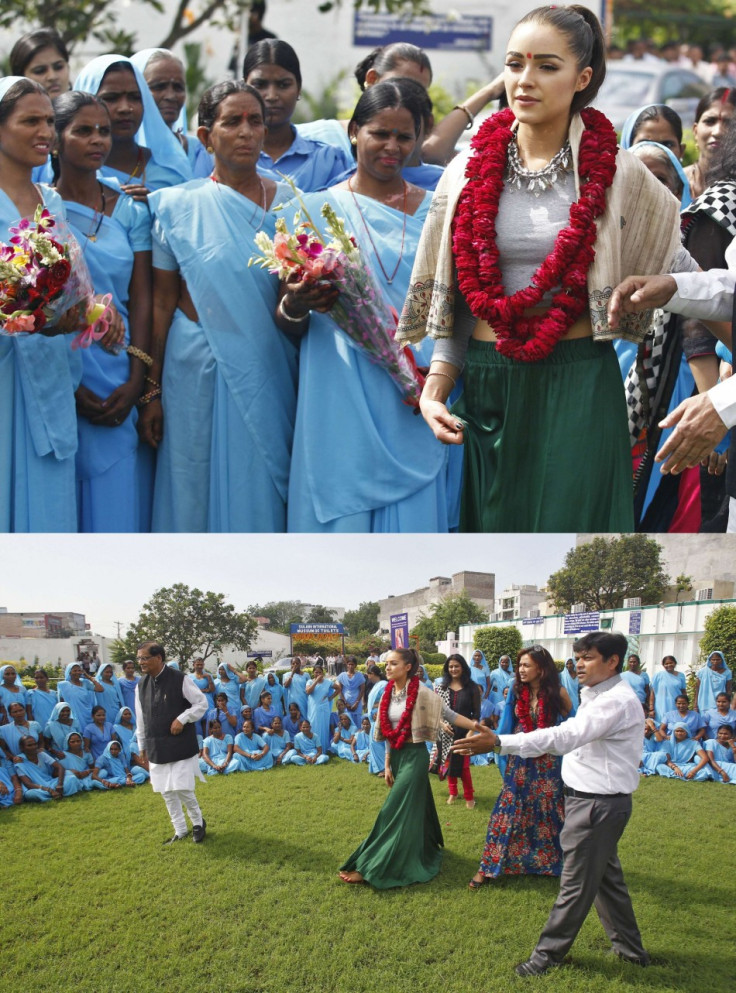 Miss Universe 2012 Culpo, wearing floral garlands, arrives to meet women at a school in New Delhi. (Photo: Miss Universe Organization)