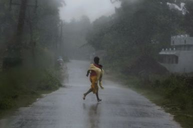 A woman runs for shelter as Cyclone Phailin strikes.