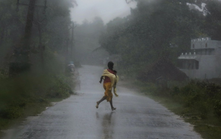 A woman runs for shelter as Cyclone Phailin strikes.