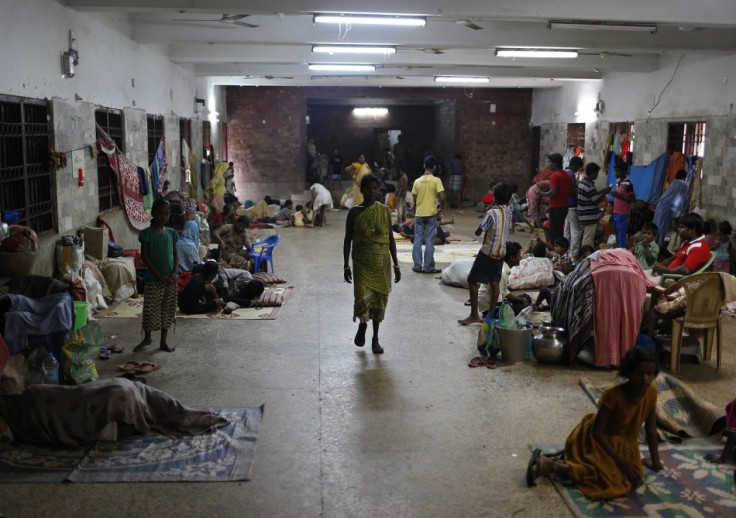 People take shelter at a wedding hall after leaving their houses to take shelter from the impact of the approaching Cyclone Phailin, in the eastern Indian state of Odisha