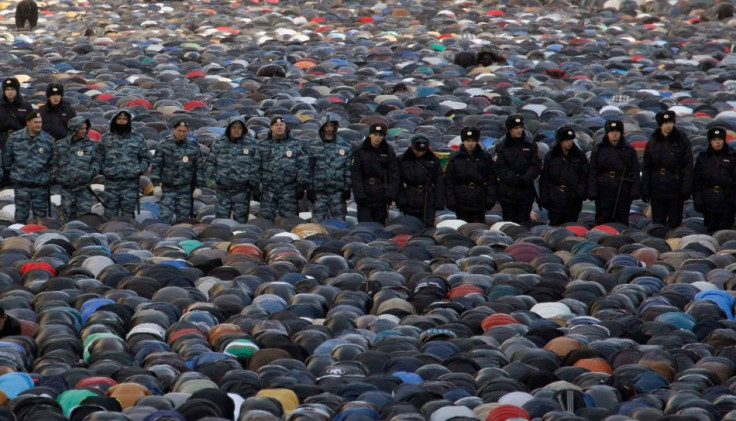 Interior Ministry members stand guard as muslims attend Eid al-Adha prayers in Moscow. (Photo: Reuters)