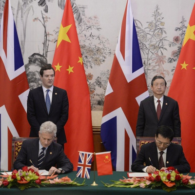 Britain's Chancellor of the Exchequer George Osborne (rear, L) stands next to Chinese Vice premier Ma Kai (rear, R), as Paul Deighton, commercial secretary to the Treasury, participates in a signing ceremony with Xu Yongsheng, deputy director of China's N