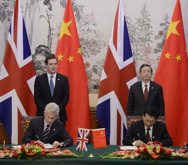 Britain's Chancellor of the Exchequer George Osborne (rear, L) stands next to Chinese Vice premier Ma Kai (rear, R), as Paul Deighton, commercial secretary to the Treasury, participates in a signing ceremony with Xu Yongsheng, deputy director of China's N