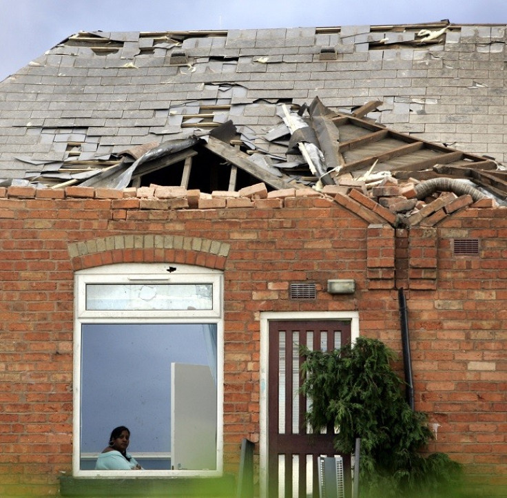 A woman sits in her damaged home after a tornado struck the Moseley area of Birmingham in central England July 28, 2005. (Reuters)