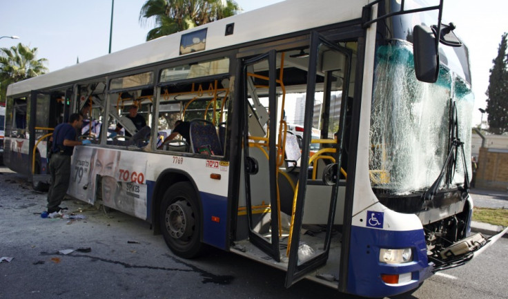Israeli police officer looks at a damaged bus after an explosion in Tel Aviv (Reuters)