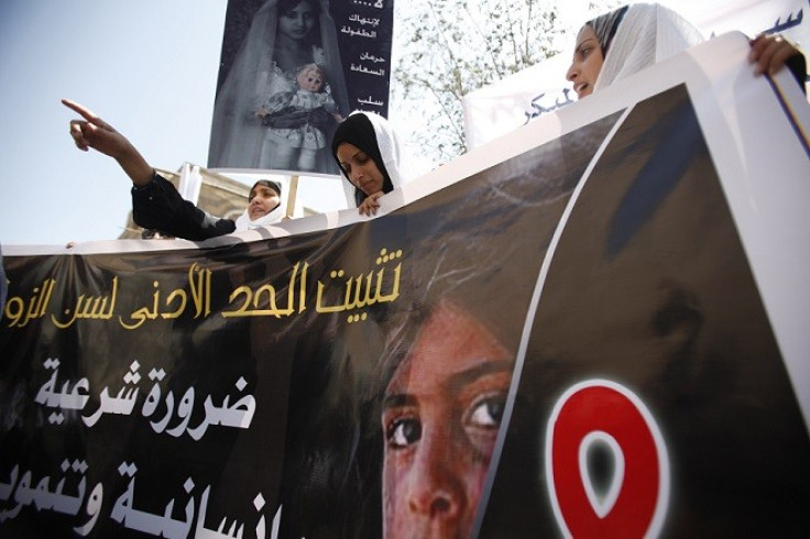 Yemeni women hold up a poster portraying a child bride during a sit-in outside the parliament (Reuters)