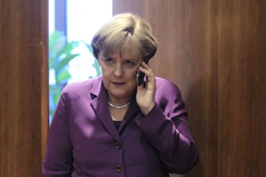 Germany's Chancellor Angela Merkel uses her mobile phone before a meeting at a European Union summit in Brussels