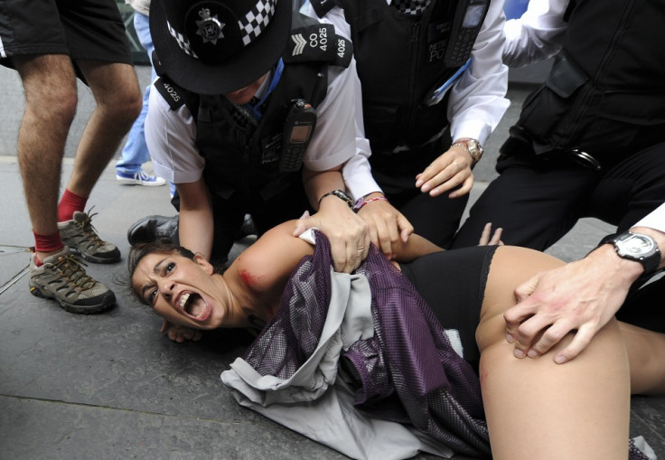 A Femen member is tackled to then group during as protest in London (Reuters)