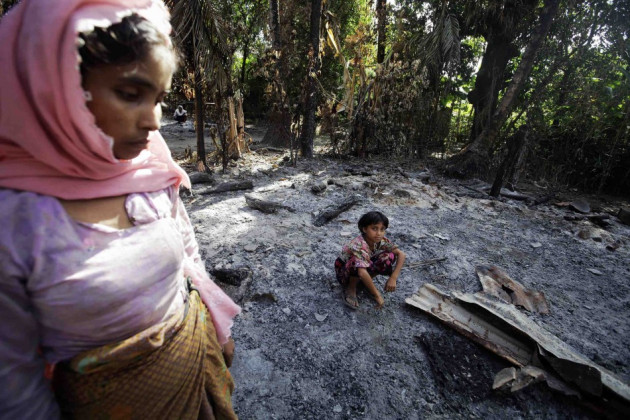 A Muslim family gather at the ruins of their home A Muslim family gather at the ruins of their home