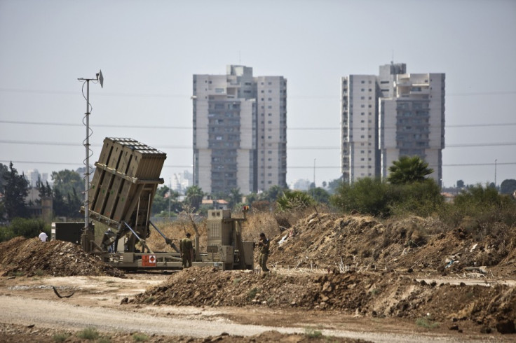 Israeli soldiers walk near an Iron Dome rocket interceptor battery
