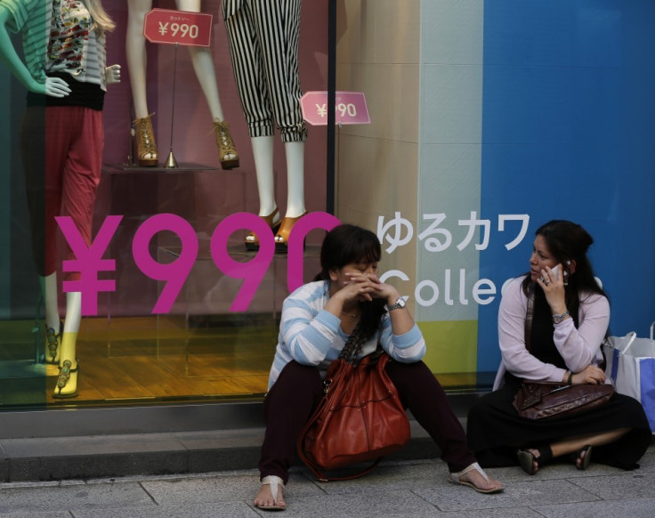 Women sit in front of a clothing store in Tokyo