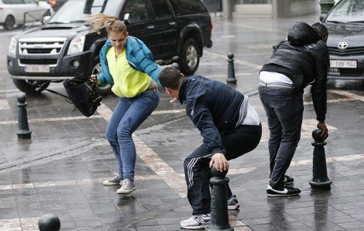 A man helps a woman to cross a square during strong winds in central Brussels (Reuters)