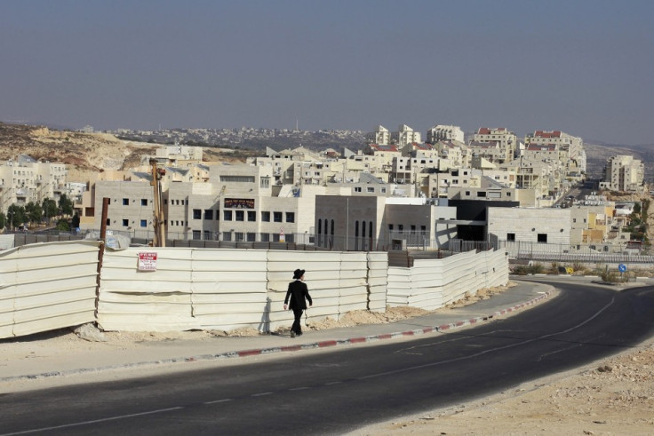 An ultra-Orthodox youth walks past a construction site in the West Bank Jewish settlement of Modiin Illit