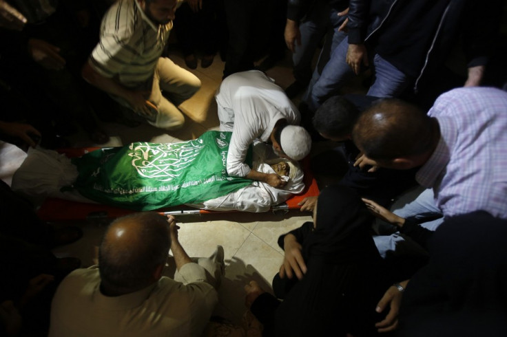 A Palestinian relative of Hamas militant Rabee Baraka kisses his body during his funeral at his family's house in Khan Younis in the southern Gaza Strip