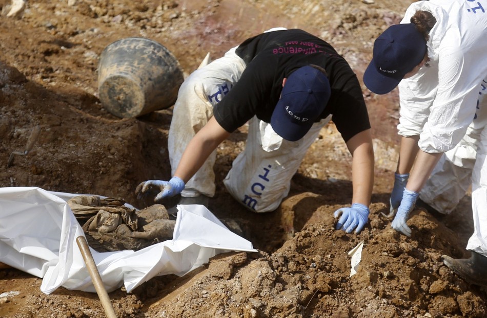 Forensic experts, members of the International Commision of Missing Persons ICMP and Bosnian workers search for human remains at a mass grave in the village of Tomasica near Prijedor