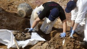 Forensic experts, members of the International Commision of Missing Persons (ICMP) and Bosnian workers search for human remains at a mass grave in the village of Tomasica near Prijedor