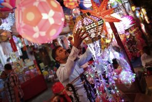 A vendor hangs lanterns for sale at a Diwali market in Mumbai. (Photo: REUTERS)