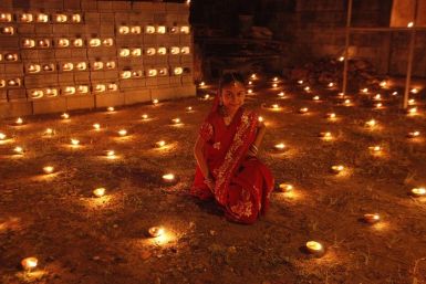 A girl sits among diyas, or oil lamps, in her yard during Diwali celebrations in Felicity, central Trinidad November 13, 2012. (Picture: Reuters)