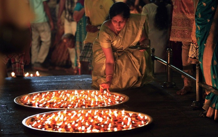 A Tamil devotee lights oil lamps during a religious ceremony to celebrate Diwali at Ponnambalavaneshwaram Hindu temple in Colombo, November 2, 2013. Picture: (Reuters)