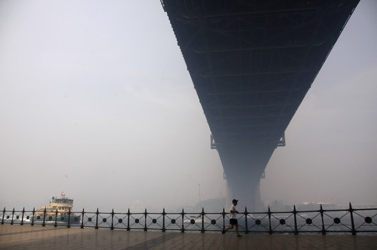A man jogs beneath a hazy Sydney Harbour Bridge