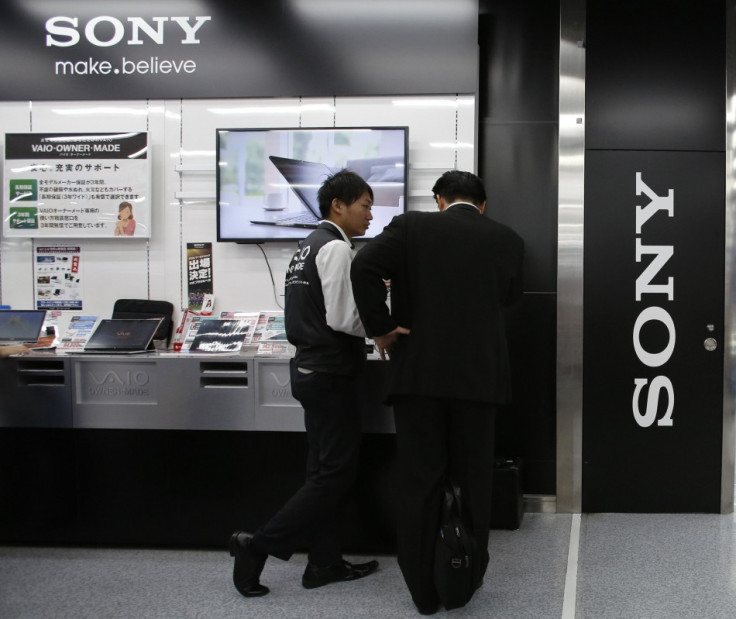 A Customer and a Clerk Talk near Sony Corp's Logo at an Electronics Store in Tokyo
