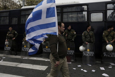 A man holds a Greek flag in front of riot policemen during a military parade to mark Greece's Independence Day in Athens March 25, 2013. (Photo: Reuters)