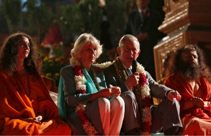 Prince Charles addresses a gathering as Camilla and the sadhus watch after they performed a puja on banks of river Ganges in Rishikesh. (Photo: Reuters)