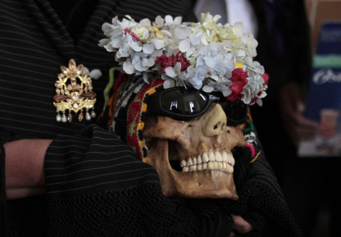 The  skulls are adorned with garlands of flowers and sometimes sunglasses.